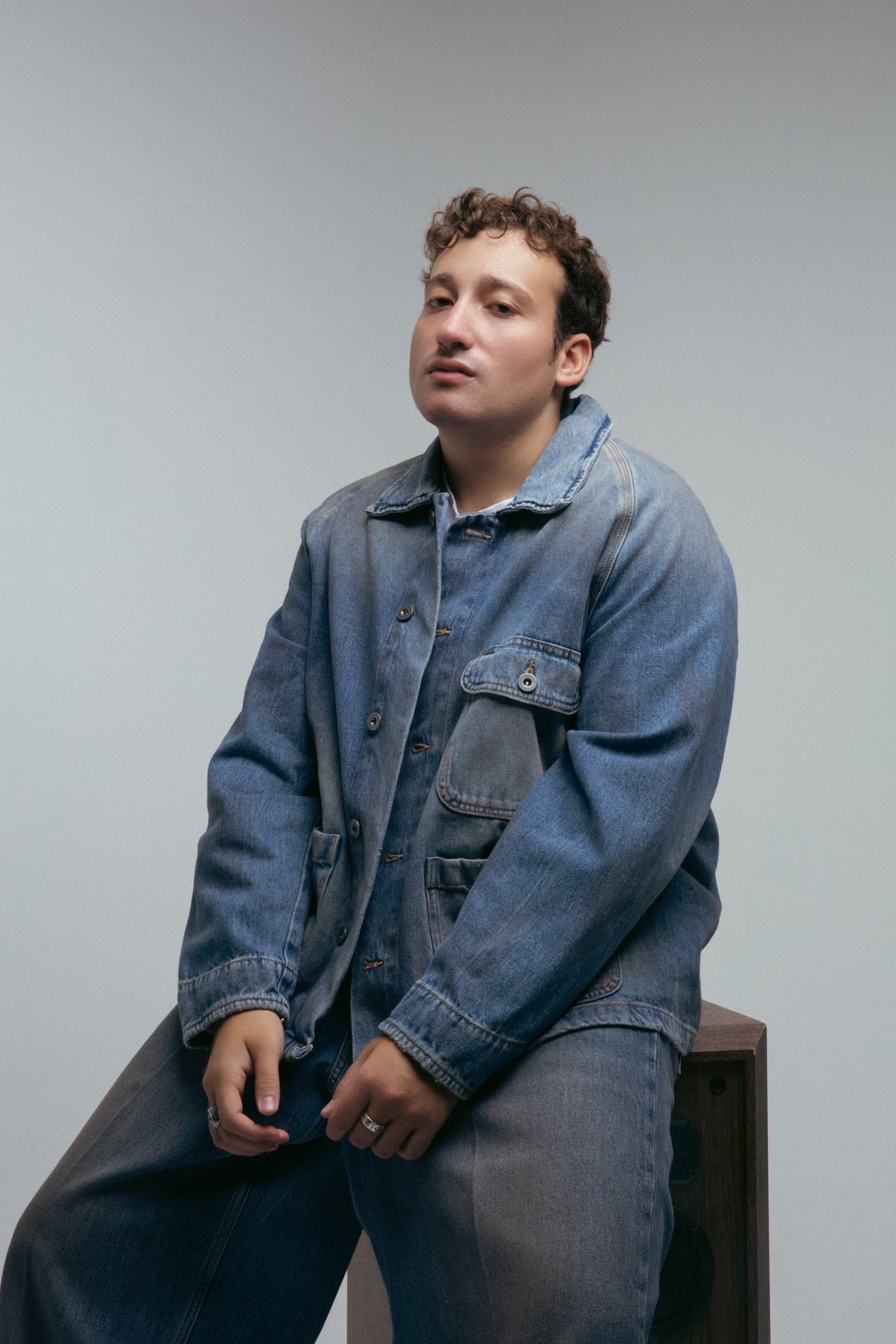 MATEO con chaqueta de denim, apoyado sobre una corneta vintage